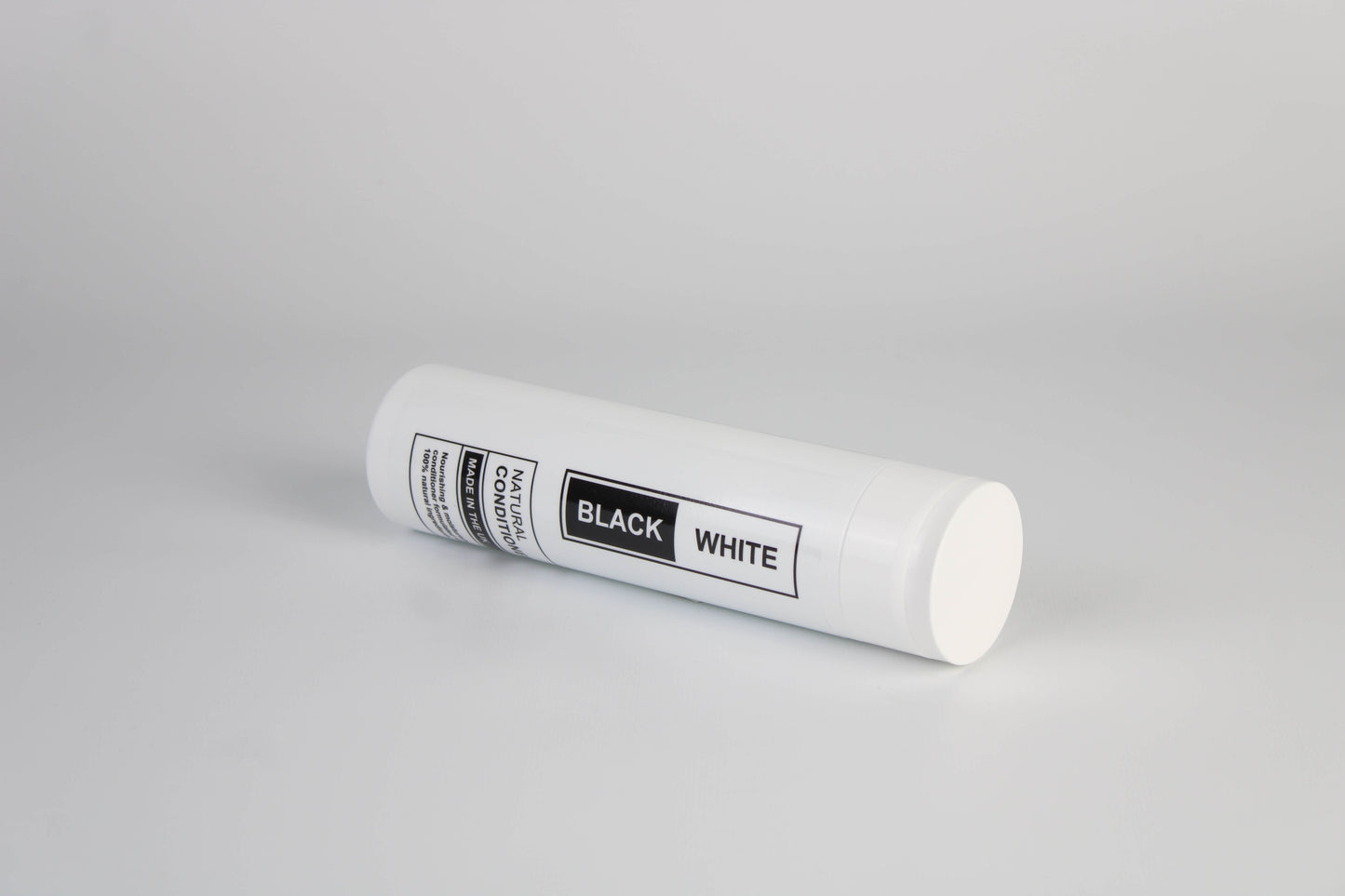 A side angle photo of Black & White's Natural Conditioner against a white background.